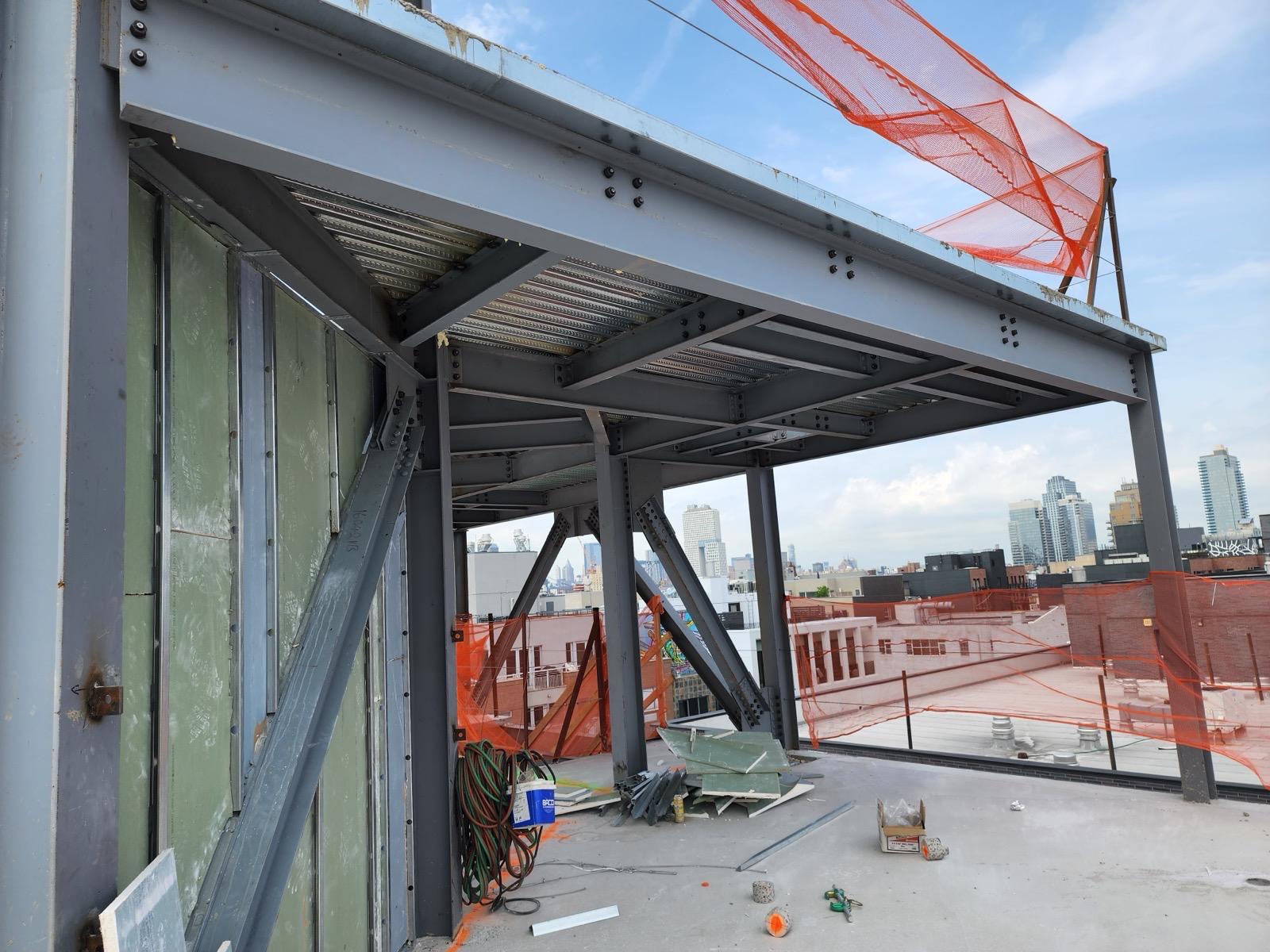Rooftop steel canopy over a city skyline