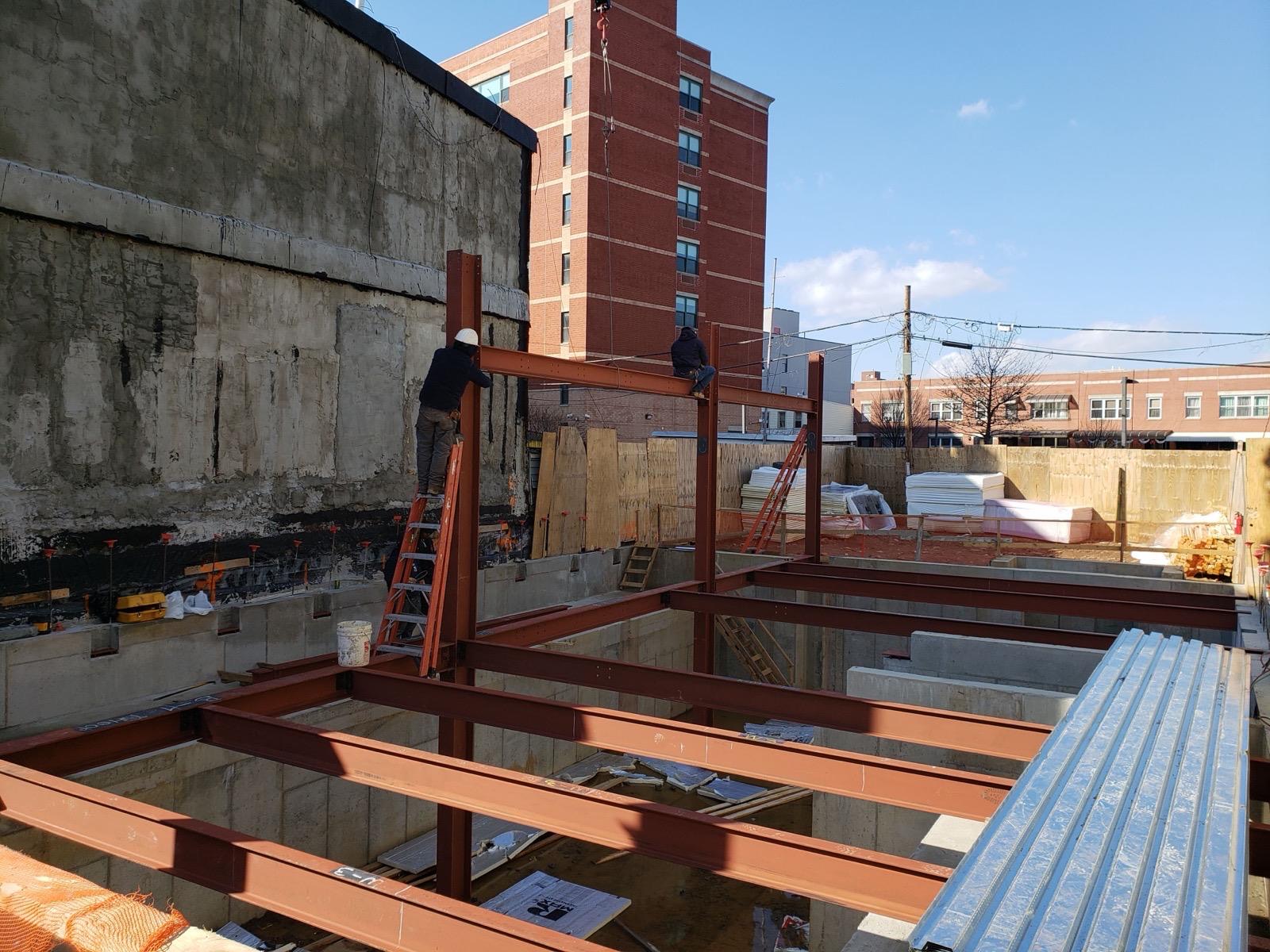 Structural steel floor framing over a foundation