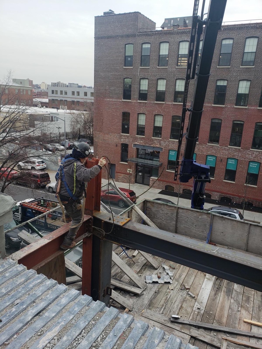 MQ Steel Corp founder on site, connecting a steel roof beam